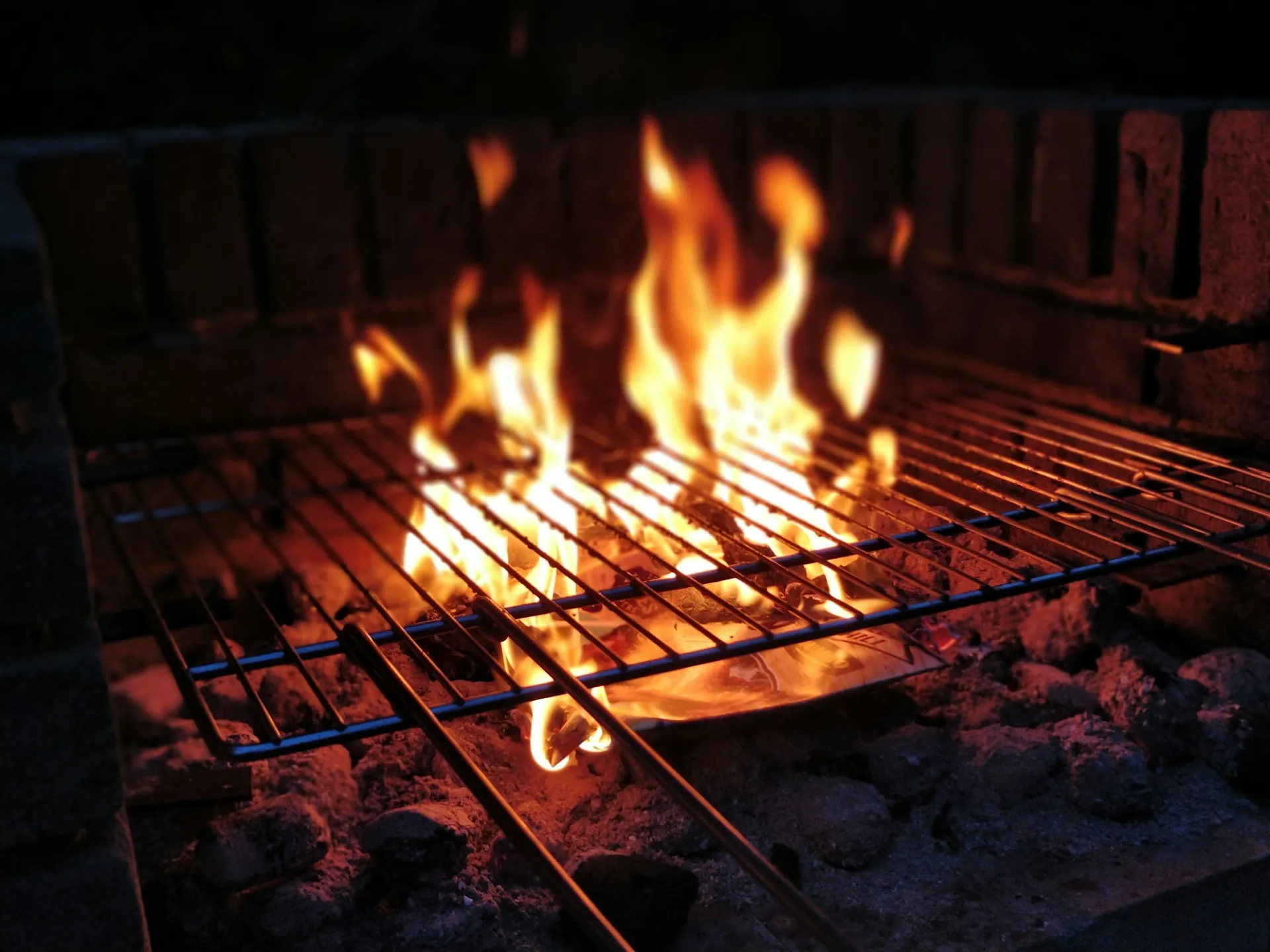 Fire burning under a charcoal grill grate