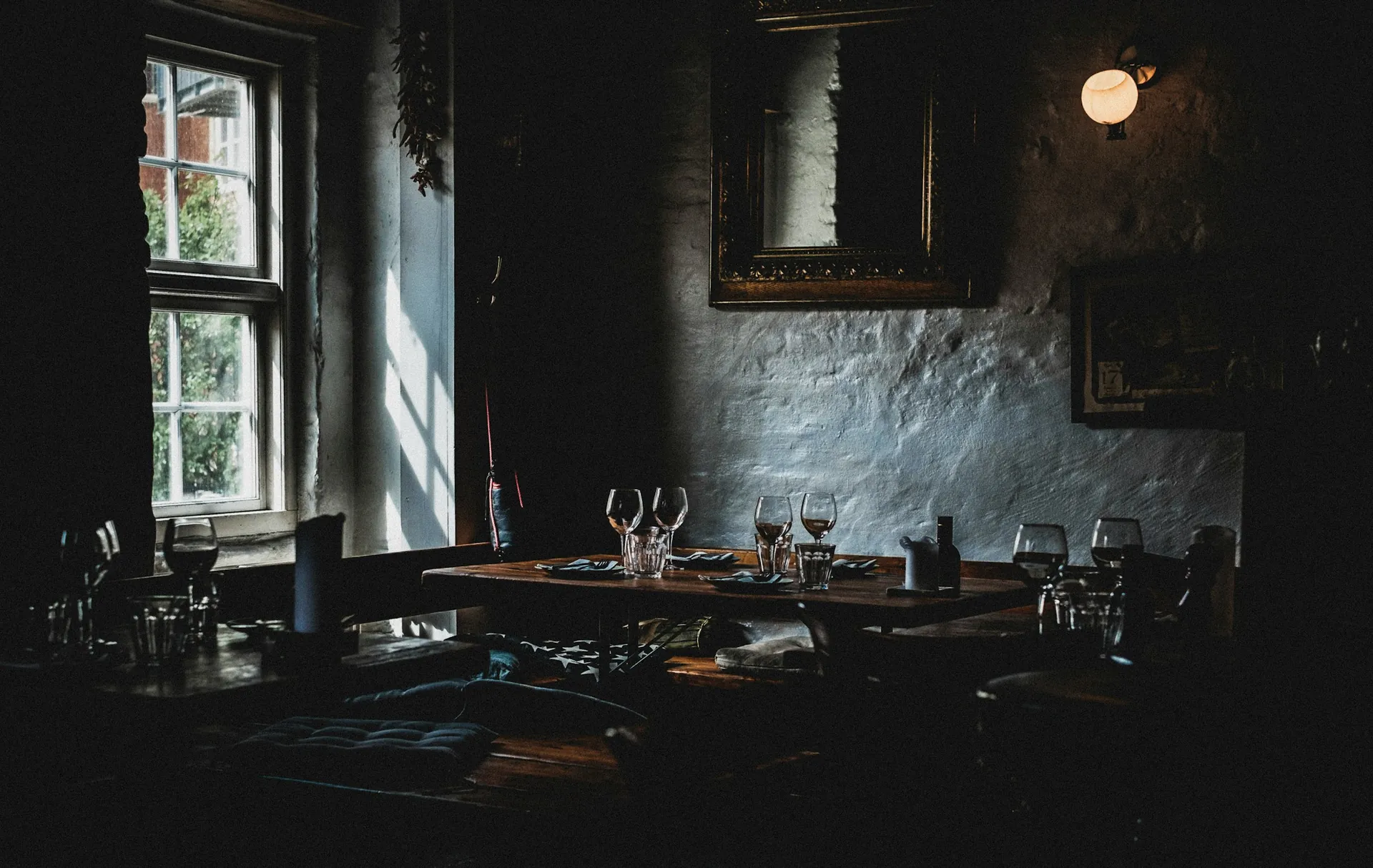 Table set by the window in a softly lit restaurant dining room