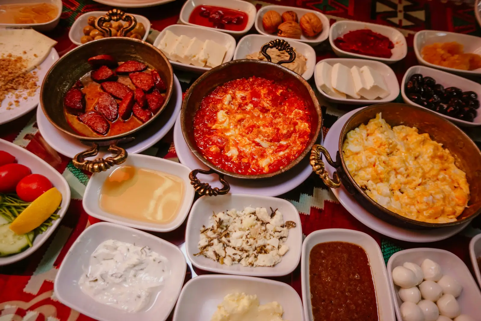 Turkish breakfast spread in small plates on a red tablecloth