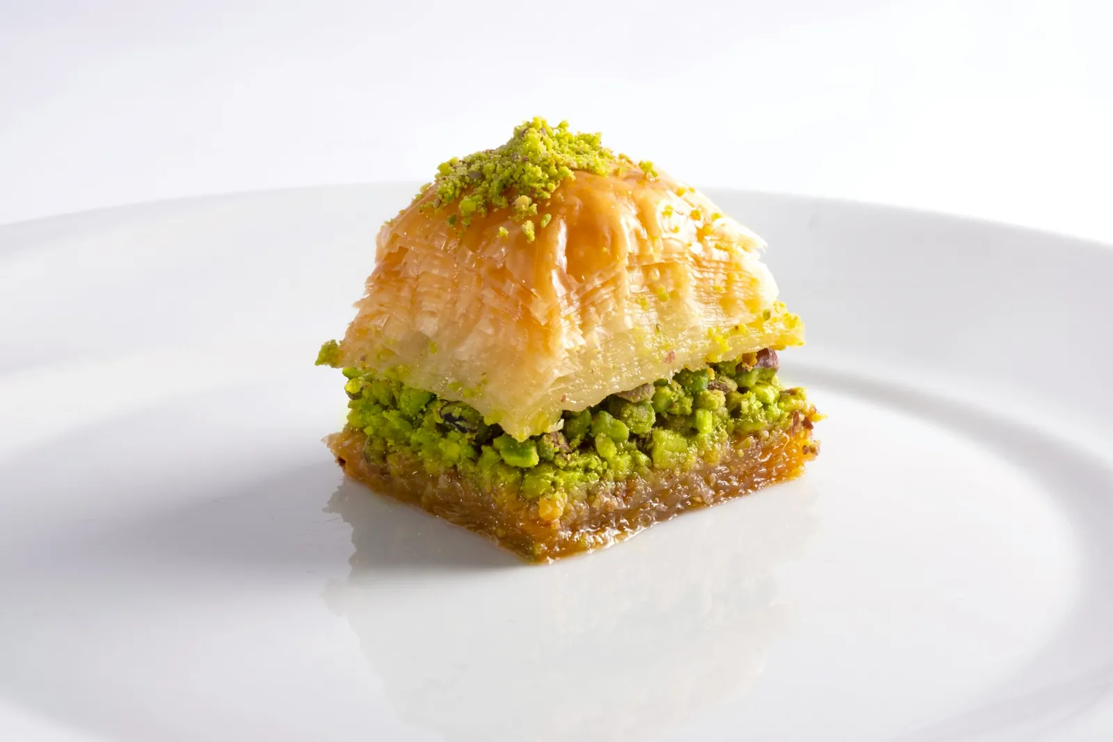 Slice of pistachio baklava on a white plate