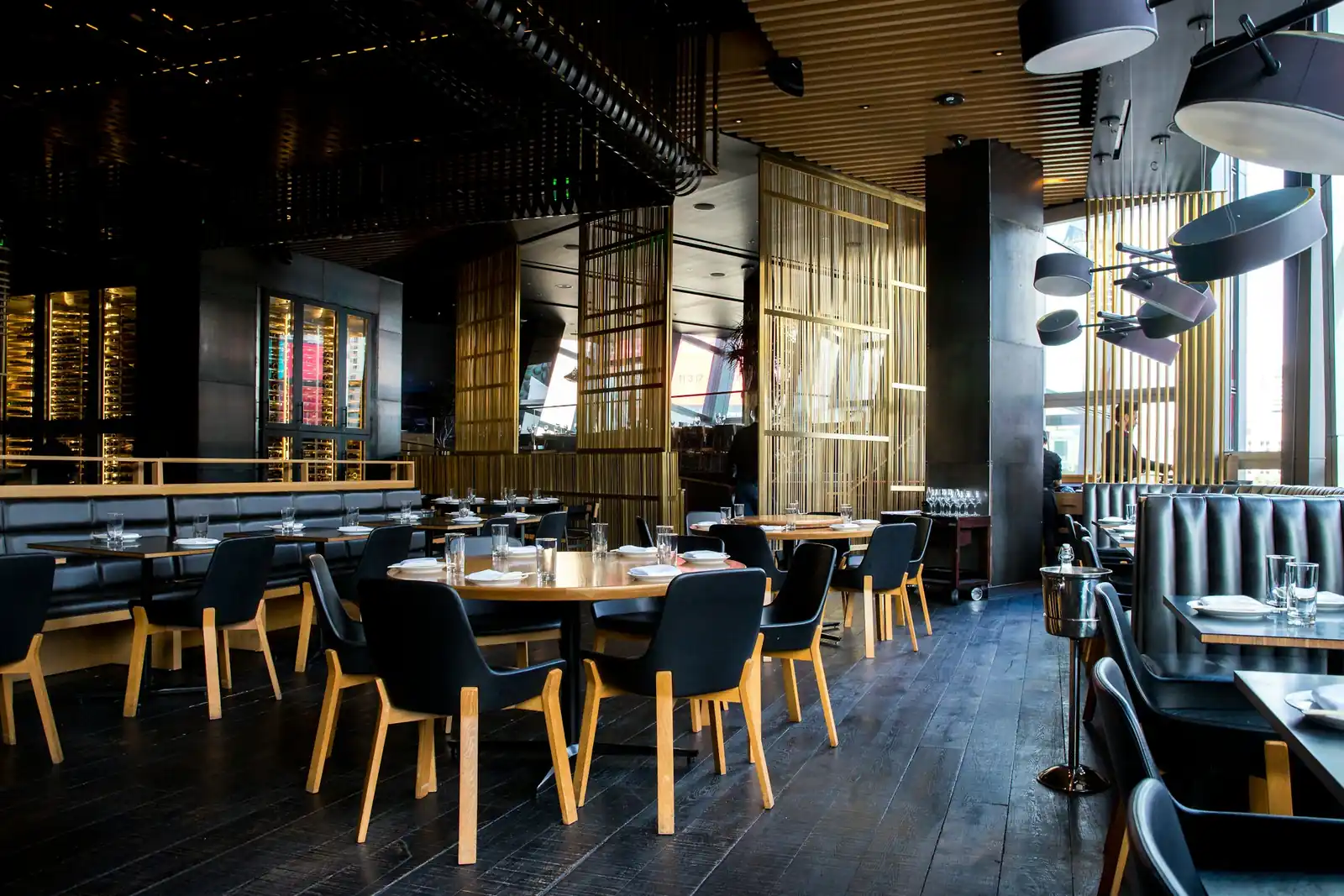 Empty restaurant dining room with wooden tables and leather chairs in the evening